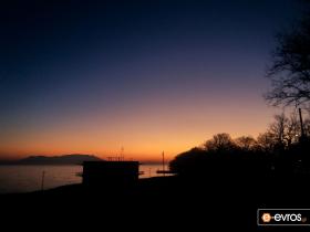 Against the background of the orange sky and the island of Samothrace